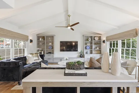 a living room with furniture a flat screen tv and a large window