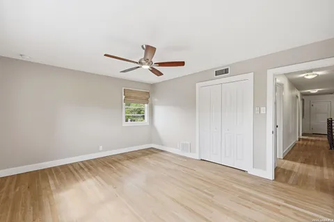 a view of a livingroom with a ceiling fan and wooden floor