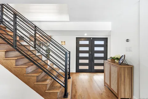 a view of a hallway with wooden floor and stairs