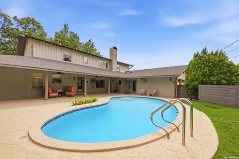 a view of a house with swimming pool and sitting area