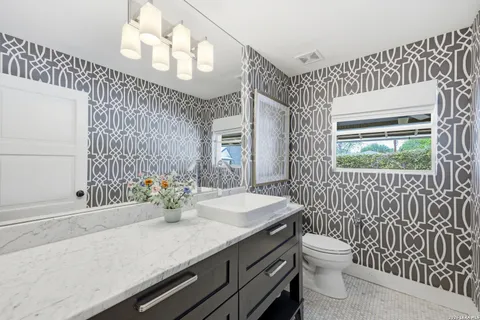 a bathroom with a sink a toilet and shower curtain