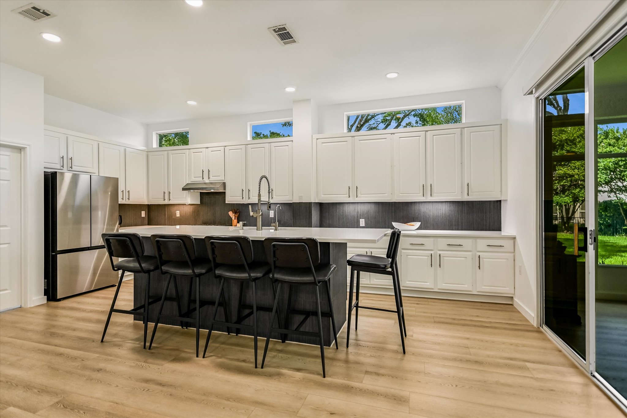 105 Stetson Circle Georgetown, TX 78633 - Photo 7 of 21 A sleek, contemporary kitchen anchored by a large island with bar seating.