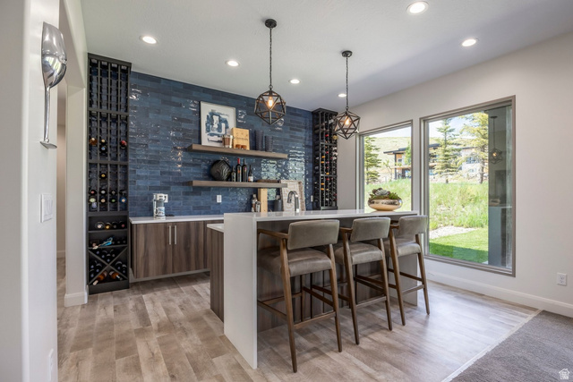 140 West Vista Road Kamas, UT 84036 - Photo 56 of 101 Custom built-in wine storage, wood-finish flooring, recessed lighting, expansive windows, and a built-in wet bar with shelving
