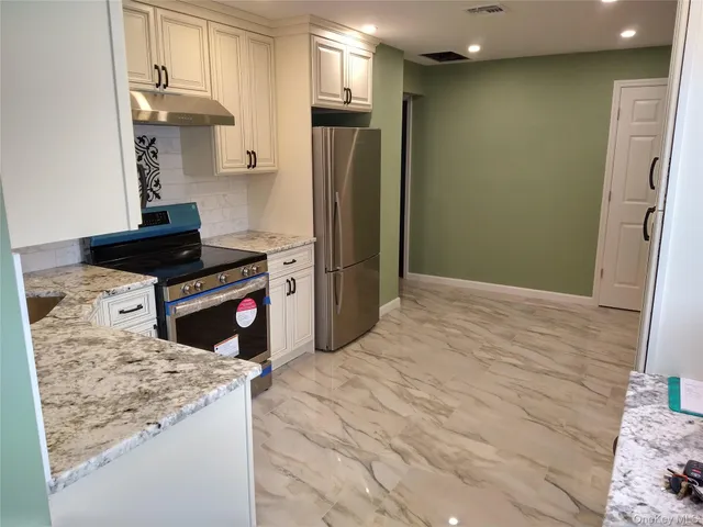 a kitchen with stainless steel appliances kitchen island a refrigerator sink and stove