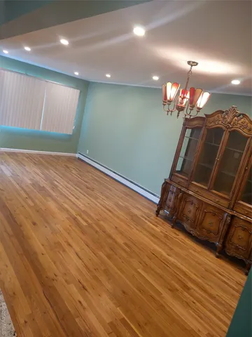 a room with wooden floor and chandelier
