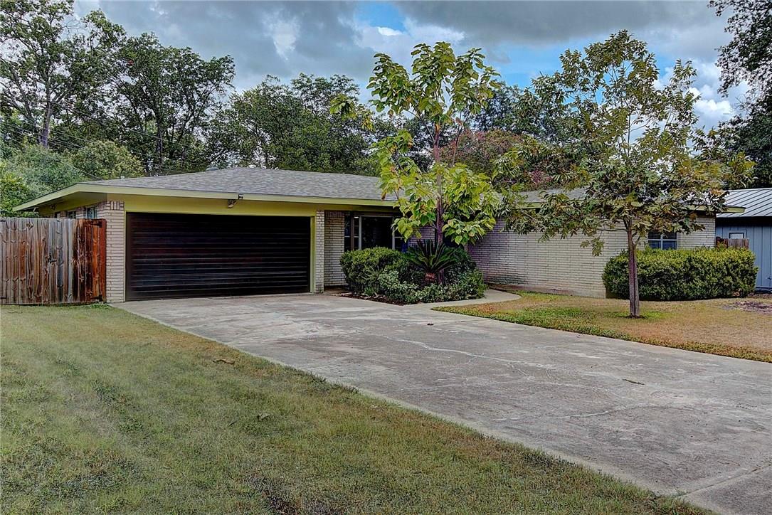 Ranch-style house featuring a garage, concrete driveway, and brick siding
