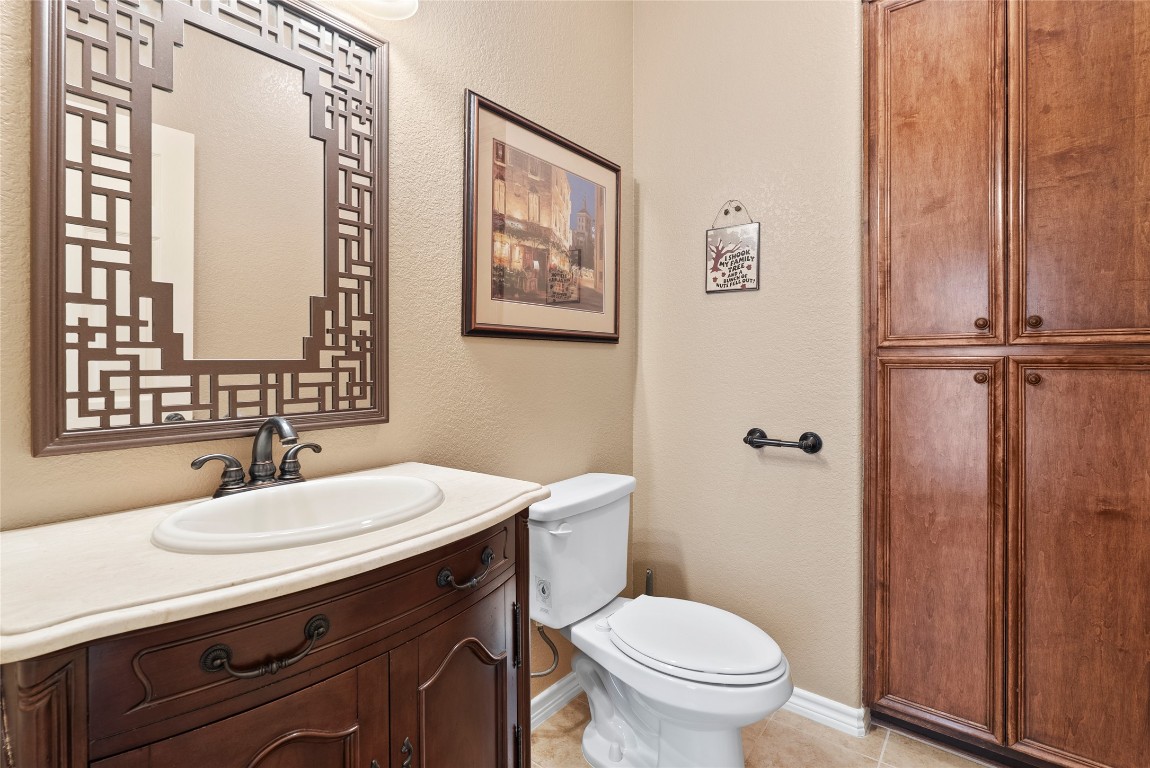 330 Arbors Circle Elgin, TX 78621 - Photo 12 of 39 Half bathroom featuring baseboards, toilet, tile patterned flooring, and vanity and storage