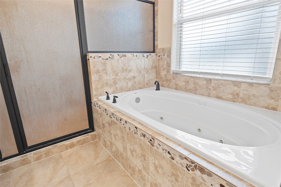 330 Arbors Circle Elgin, TX 78621 - Photo 19 of 39 Bathroom with a stall shower, tile patterned floors, and a jetted tub