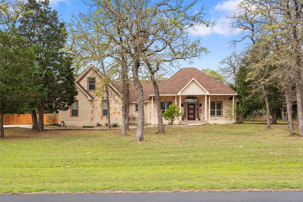 330 Arbors Circle Elgin, TX 78621 - Photo 2 of 39 View of front of house featuring a front yard, fence, stone siding, and roof with shingles