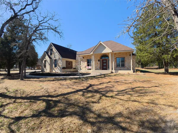 a kitchen with stainless steel appliances granite countertop wooden cabinets a sink a stove a refrigerator and dishwasher with wooden floor