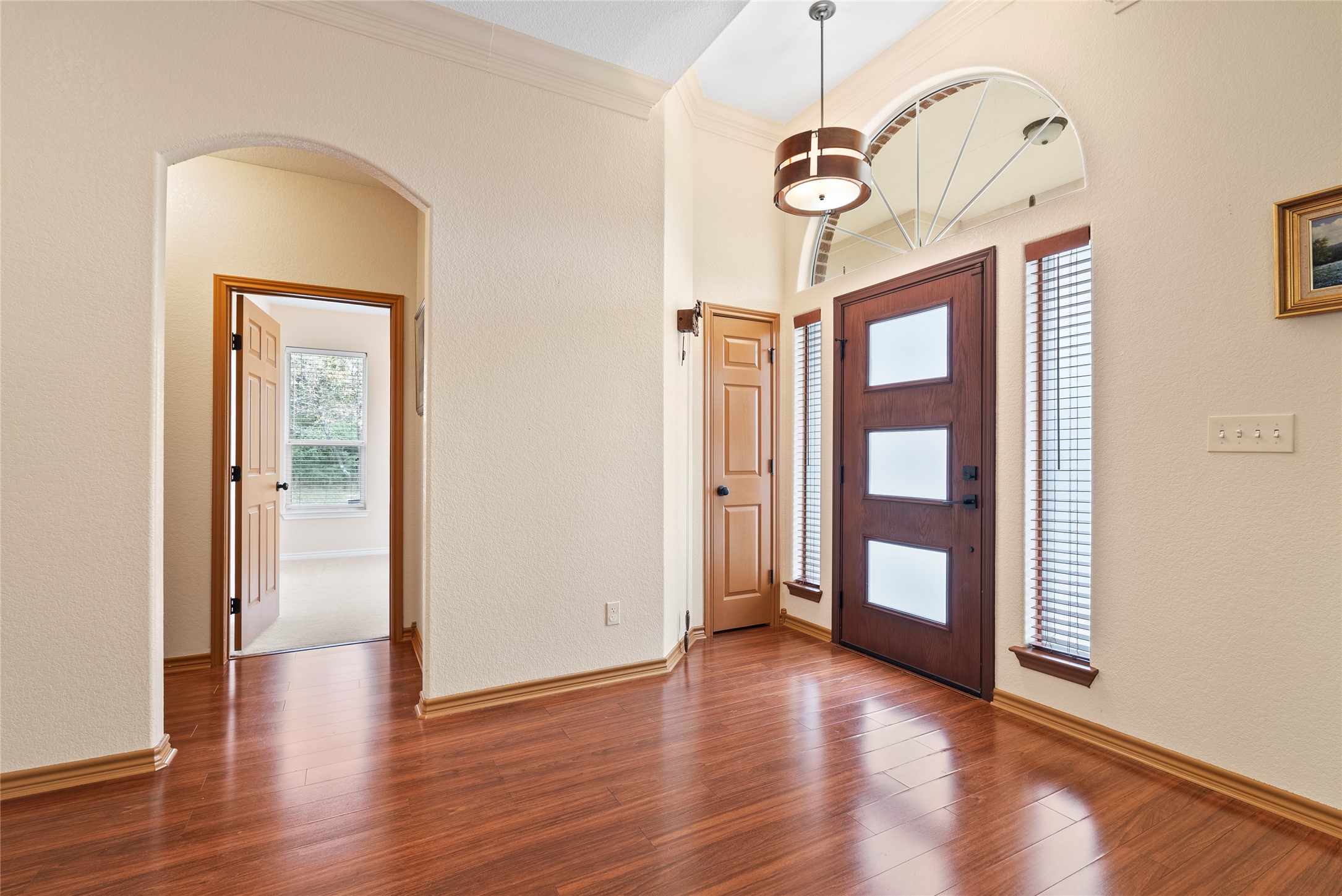 330 Arbors Circle Elgin, TX 78621 - Photo 24 of 36 Entryway with ornamental molding, arched walkways, baseboards, and wood finished floors