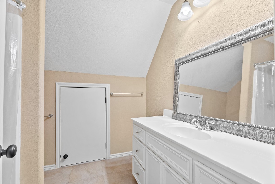 330 Arbors Circle Elgin, TX 78621 - Photo 27 of 39 Bathroom featuring tile patterned floors, vanity, baseboards, and lofted ceiling