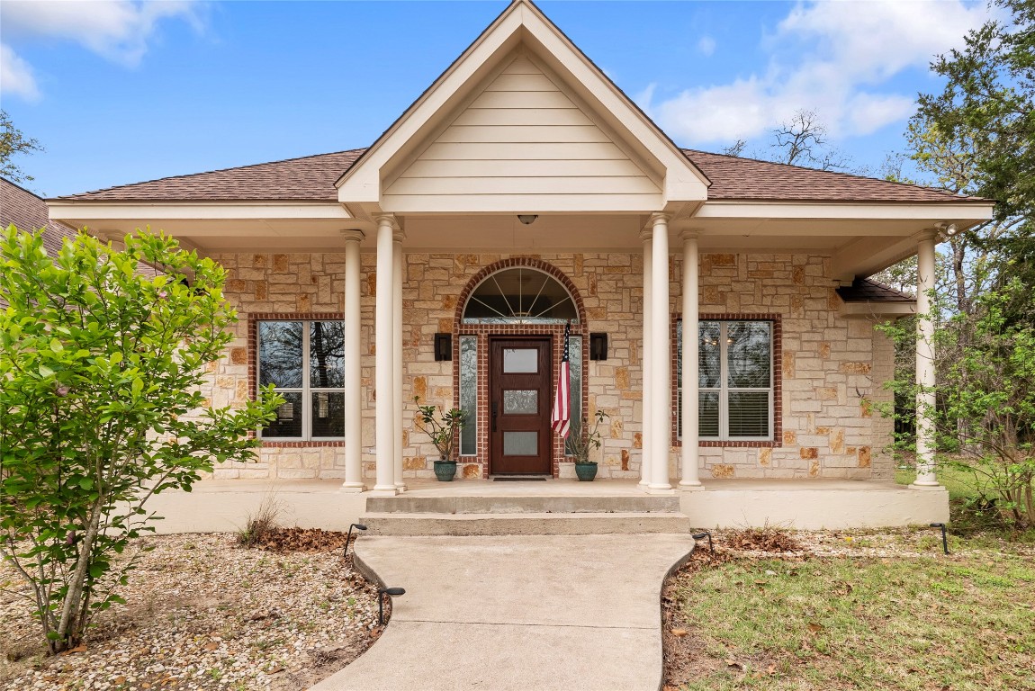 330 Arbors Circle Elgin, TX 78621 - Photo 35 of 39 Doorway to property with a shingled roof, covered porch, and stone siding