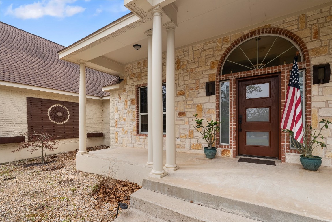 330 Arbors Circle Elgin, TX 78621 - Photo 36 of 39 Entrance to property featuring stone siding, brick siding, a porch, and roof with shingles