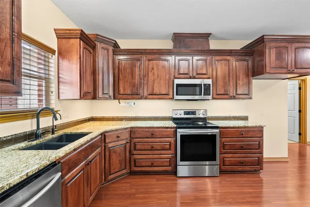 a kitchen with stainless steel appliances granite countertop a stove microwave and cabinets