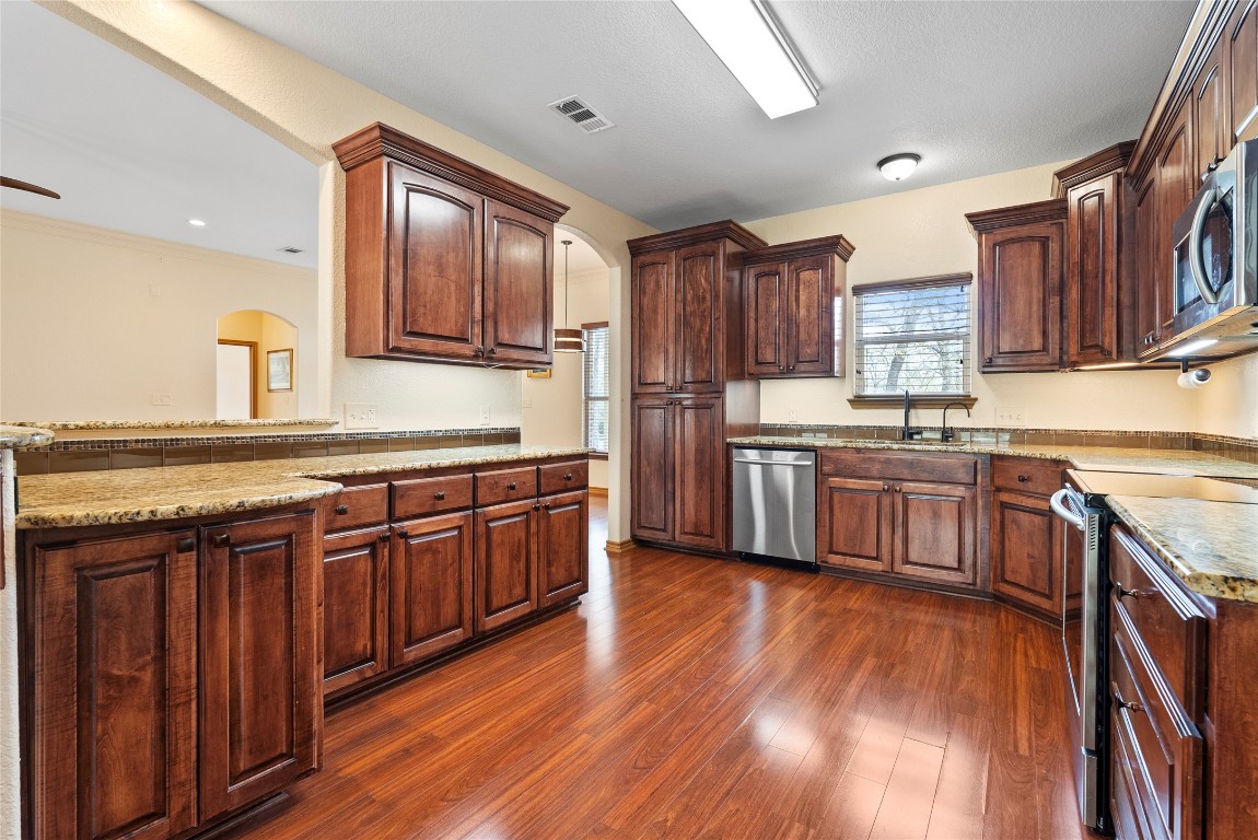 330 Arbors Circle Elgin, TX 78621 - Photo 5 of 39 Kitchen featuring a sink, stainless steel appliances, arched walkways, and visible vents