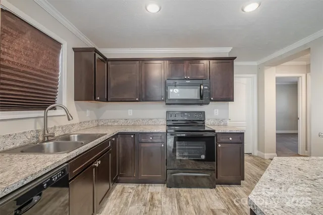 a kitchen with stainless steel appliances granite countertop a sink stove and refrigerator