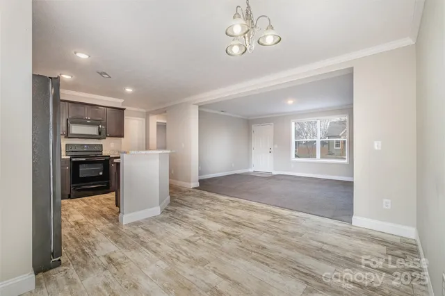a view of a kitchen with furniture and stainless steel appliances