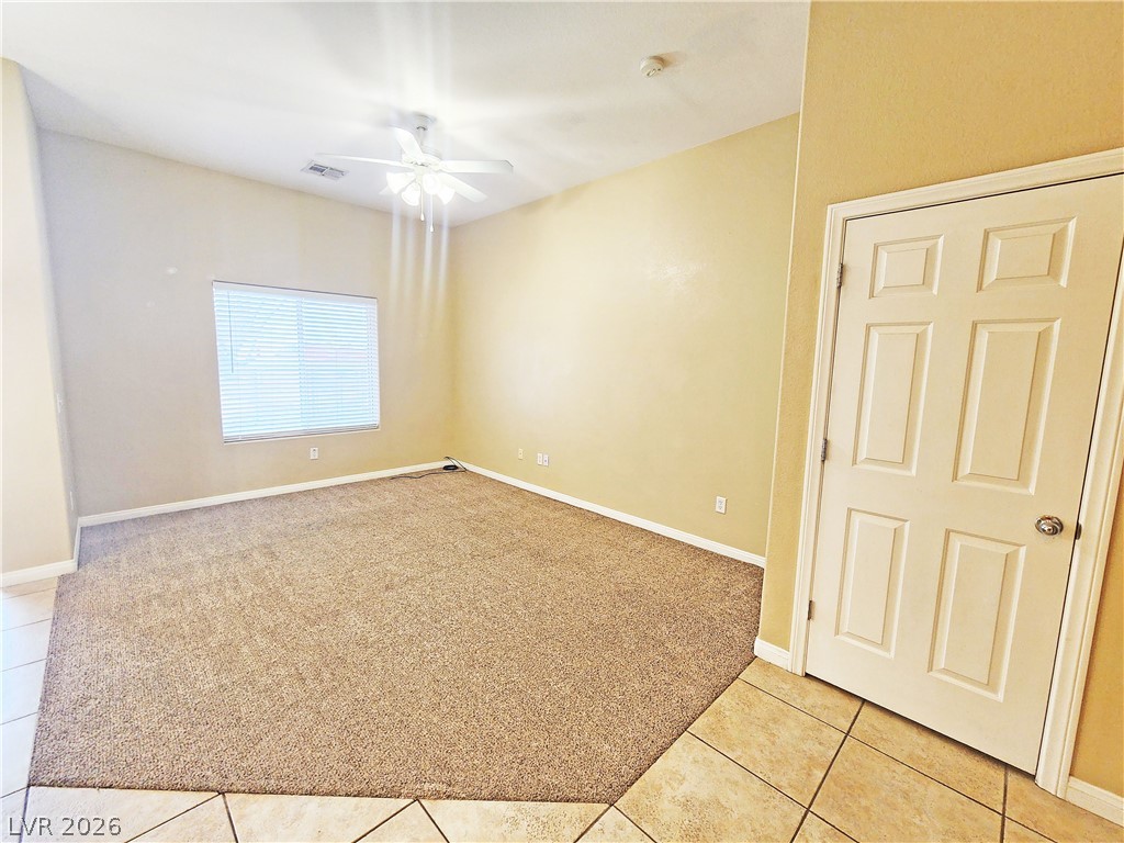 1421 Star Road, Unit 2 Pahrump, NV 89048 - Photo 9 of 33 Unfurnished room with visible vents, baseboards, light colored carpet, a ceiling fan, and light tile patterned floors