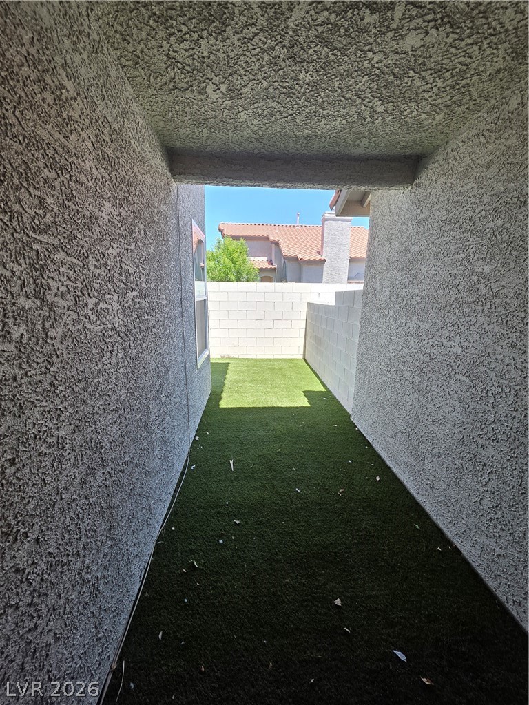 2275 Ramsgate Drive Henderson, NV 89074 - Photo 19 of 84 An enclosed outdoor area with artificial turf and sun-drenched walls provides a private green space.