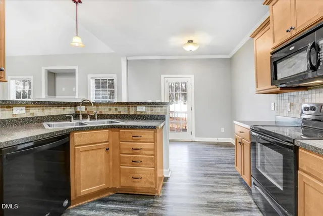 a kitchen with granite countertop a sink stainless steel appliances and cabinets