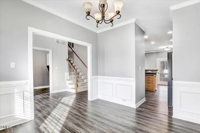 a view of an empty room with wooden floor fireplace and a window