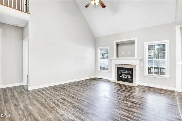 a view of a livingroom with wooden floor and a fireplace