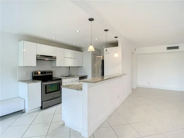 a kitchen with a stove a sink and a refrigerator