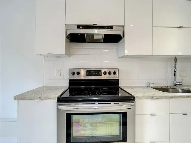 a stove top oven sitting inside of a kitchen