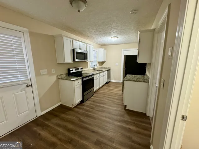 a kitchen with granite countertop a sink and steel appliances