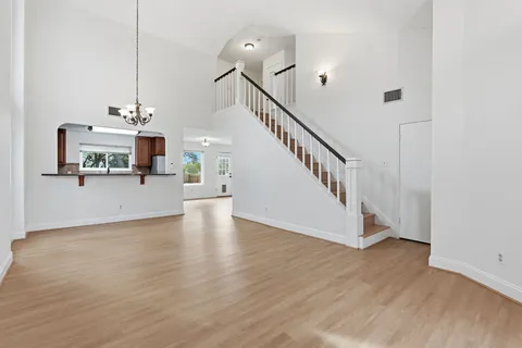 a view of a kitchen with a sink a refrigerator a kitchen island and a chandelier