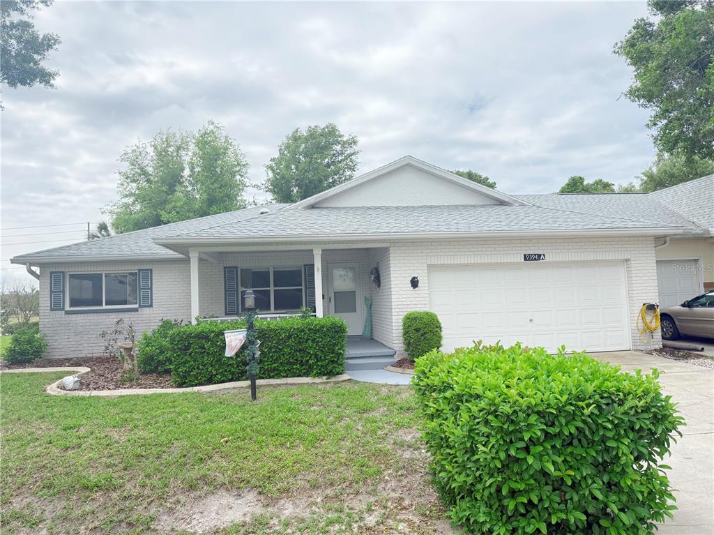 9394 Southwest 97th Lane, Unit A Ocala, FL 34481 - Photo 1 of 22 a front view of a house with garden