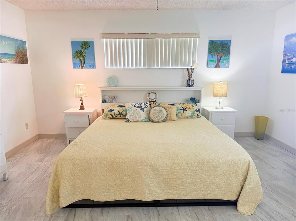 9394 Southwest 97th Lane, Unit A Ocala, FL 34481 - Photo 13 of 22 a bedroom with a bed and wooden floor