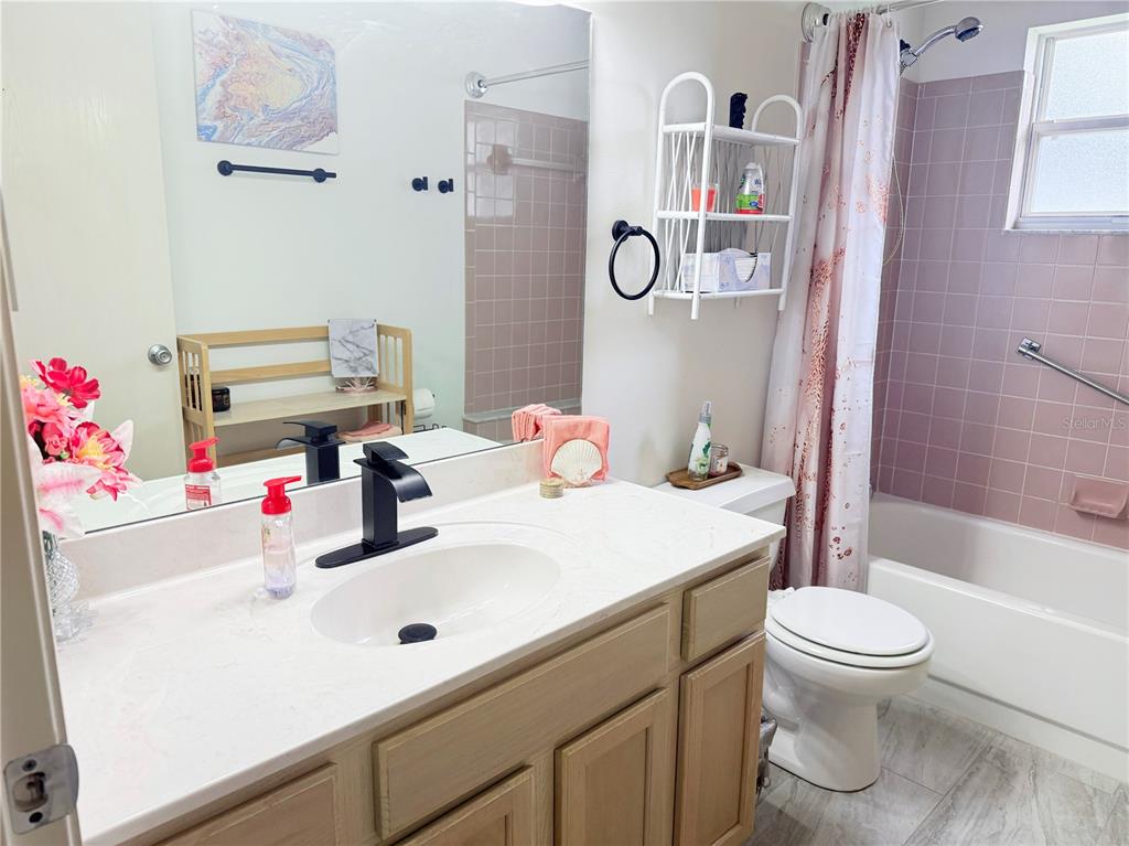 9394 Southwest 97th Lane, Unit A Ocala, FL 34481 - Photo 18 of 22 a bathroom with a sink vanity mirror and toilet