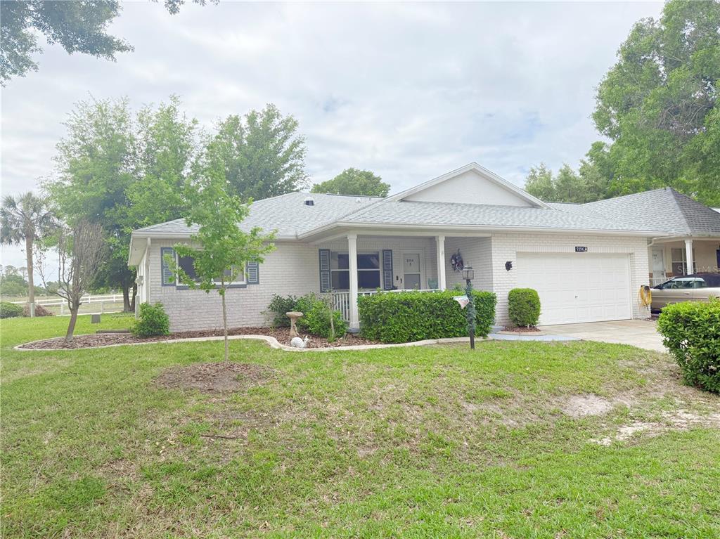 9394 Southwest 97th Lane, Unit A Ocala, FL 34481 - Photo 2 of 22 a front view of a house with a yard and garage