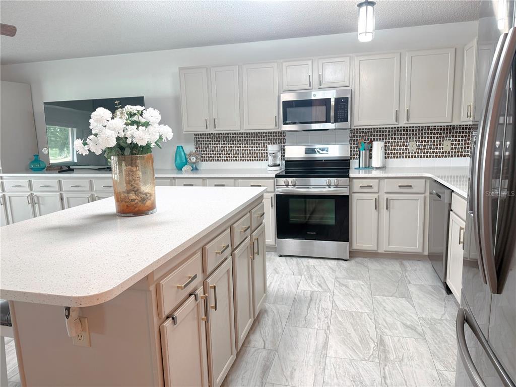 9394 Southwest 97th Lane, Unit A Ocala, FL 34481 - Photo 9 of 22 a kitchen with stainless steel appliances granite countertop a white cabinets a stove top oven a sink and dishwasher