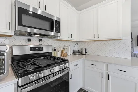 a kitchen with stainless steel appliances a stove a microwave and cabinets