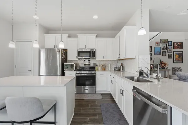 a kitchen with stainless steel appliances granite countertop a sink refrigerator stove and microwave