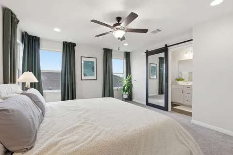 a bedroom with a large bed and a chandelier