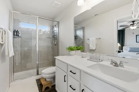 a bathroom with a sink a toilet and shower
