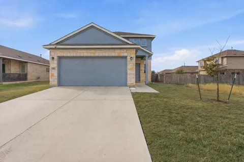 a front view of a house with a yard and garage