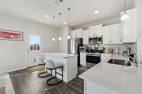 a kitchen with kitchen island white cabinets and stainless steel appliances
