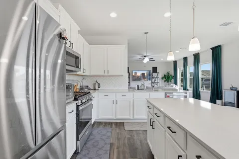 a kitchen with white cabinets and stainless steel appliances