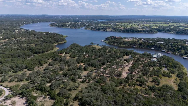 an aerial view of house with yard and lake view in back