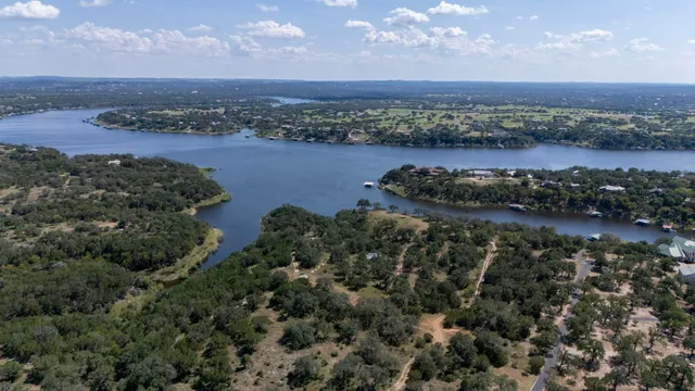 an aerial view of a house with a yard and large trees