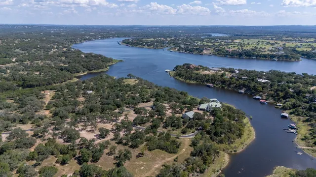 an aerial view of lake and residential houses with outdoor space