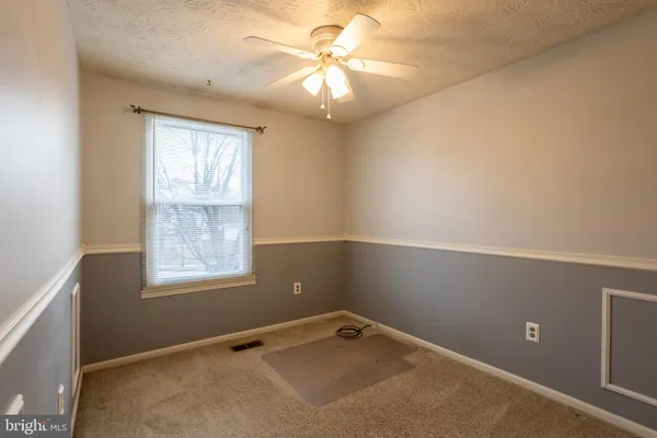 an empty room with a window and a fan