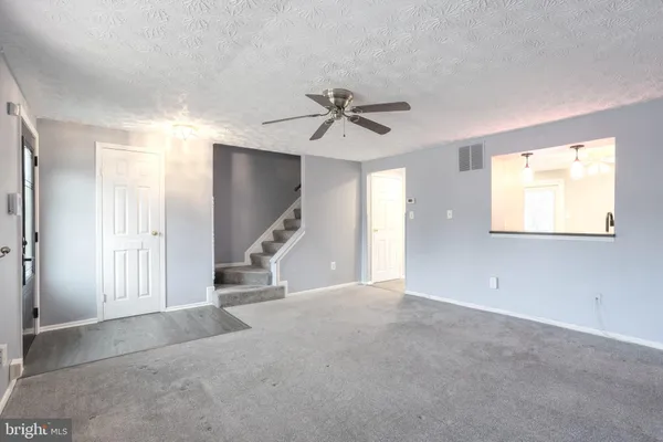 a view of a livingroom with a ceiling fan and window