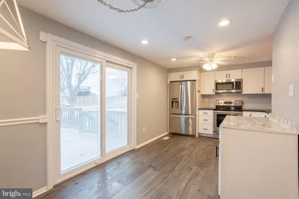 a kitchen with a refrigerator a stove top oven and a large window