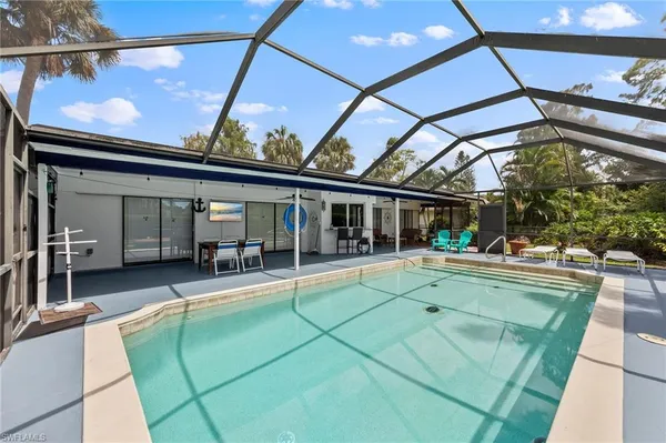 a view of house with swimming pool and outdoor seating